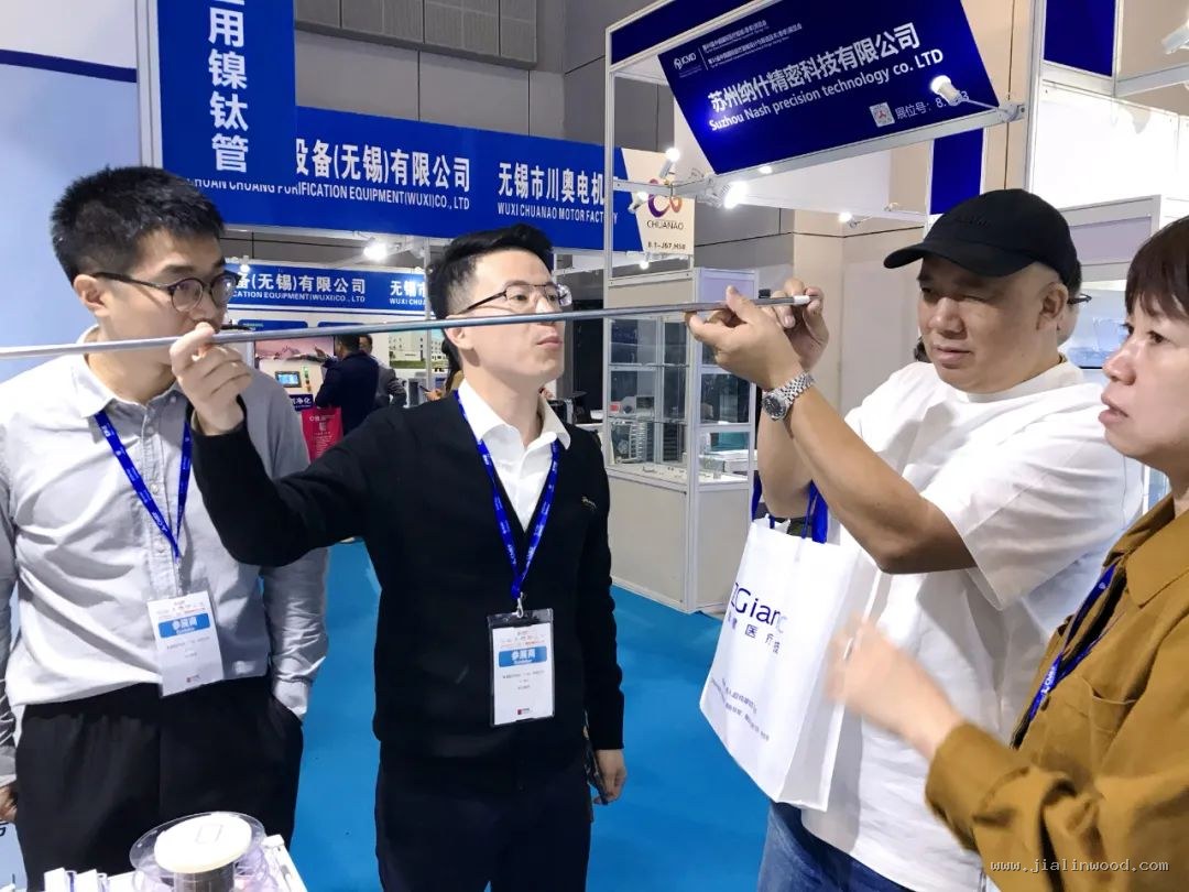 展位前的商务接待与产品洽谈，接待人员为来访客商细致讲解。